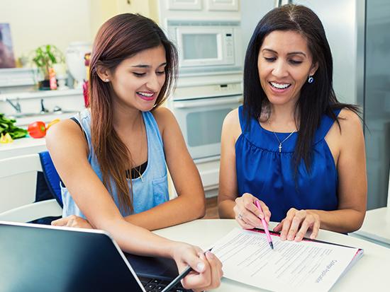 Two women looking at a notebook